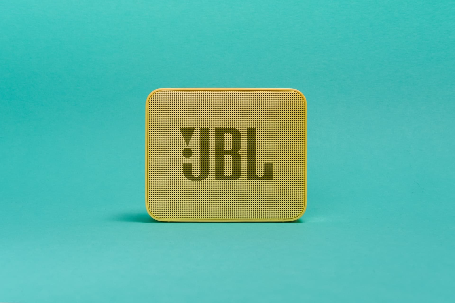 Enceinte Bluetooth JBL sur fond vert d'eau