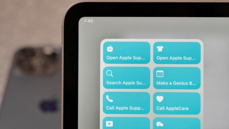 Photo des raccourcis liés à l'assistance Apple dans un grand widget sur l'iPad, avec un iPhone affiché en arrière-plan.
