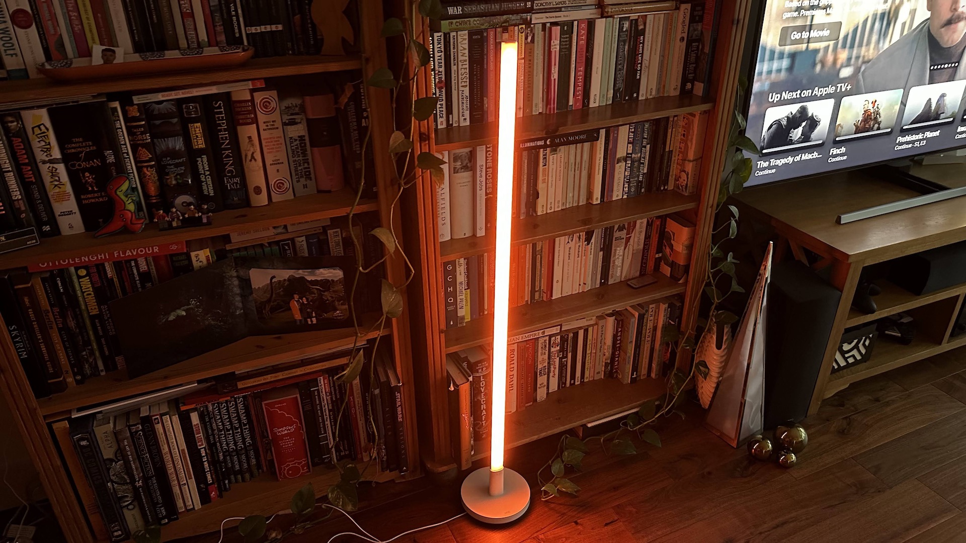 Wiz Luminaire Pole Floor Light orange brillant dans un coin salon.