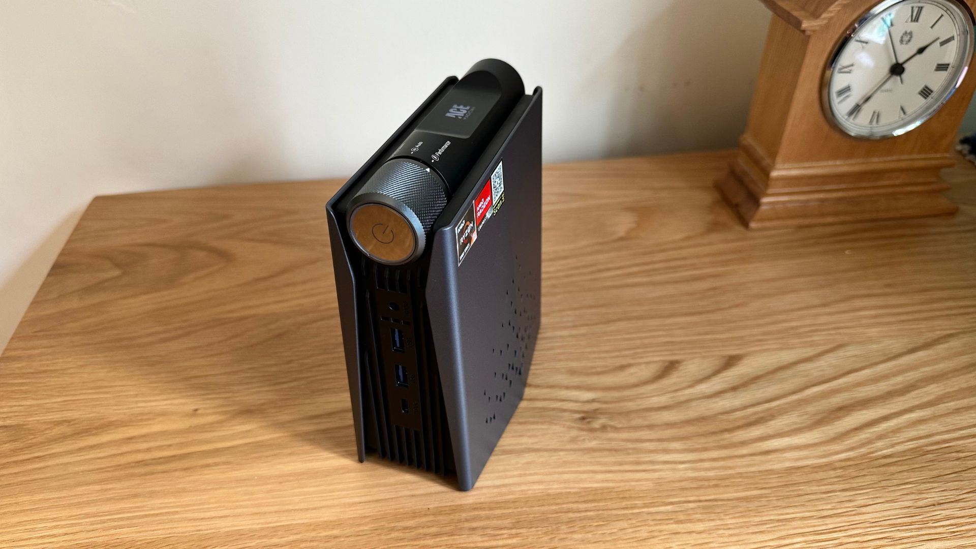 AceMagician AMR5 mini PC on a wooden sideboard