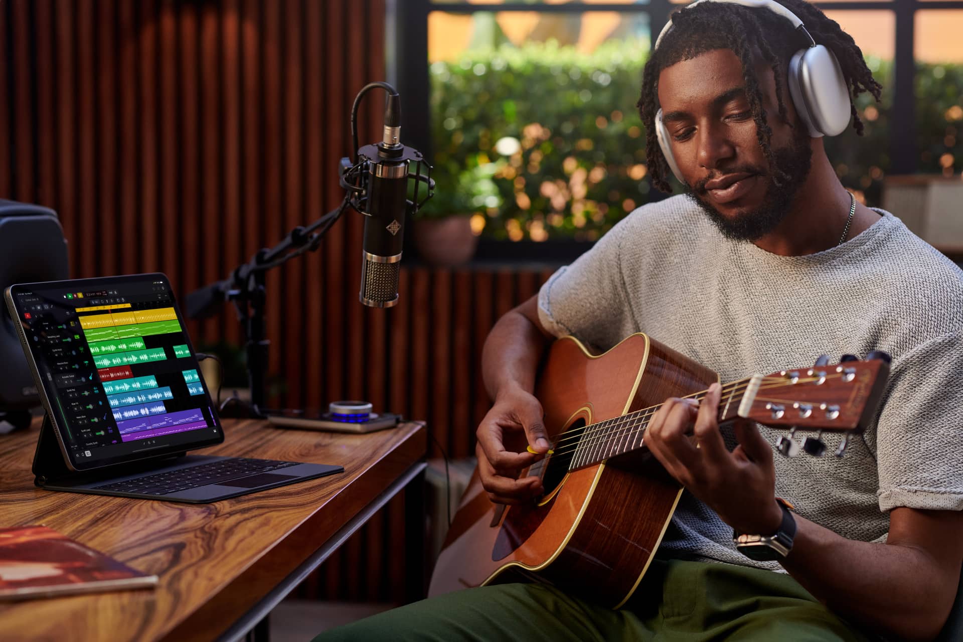 Une personne dans son home studio enregistrant une session de guitare avec Logic Pro pour iPad