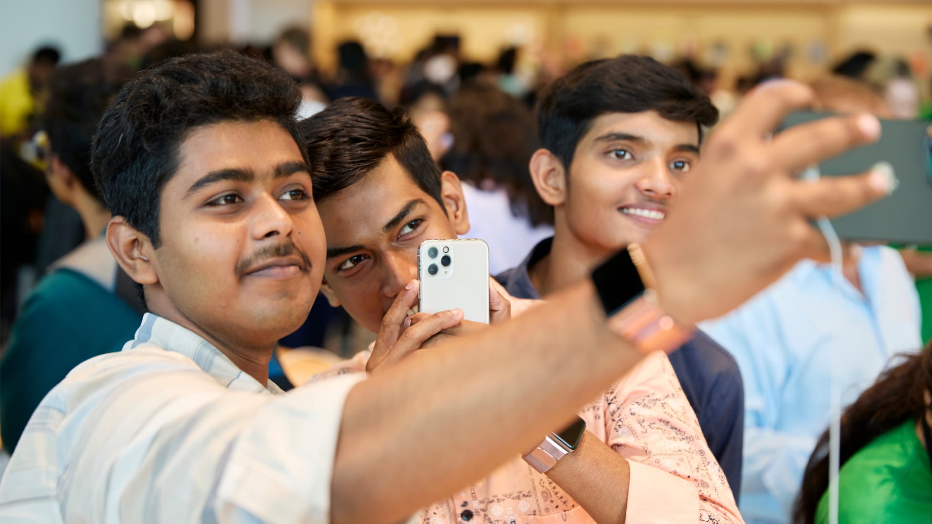 Gros plan d'un jeune homme prenant un selfie avec un iPhone dans la boutique Apple de Mumbai