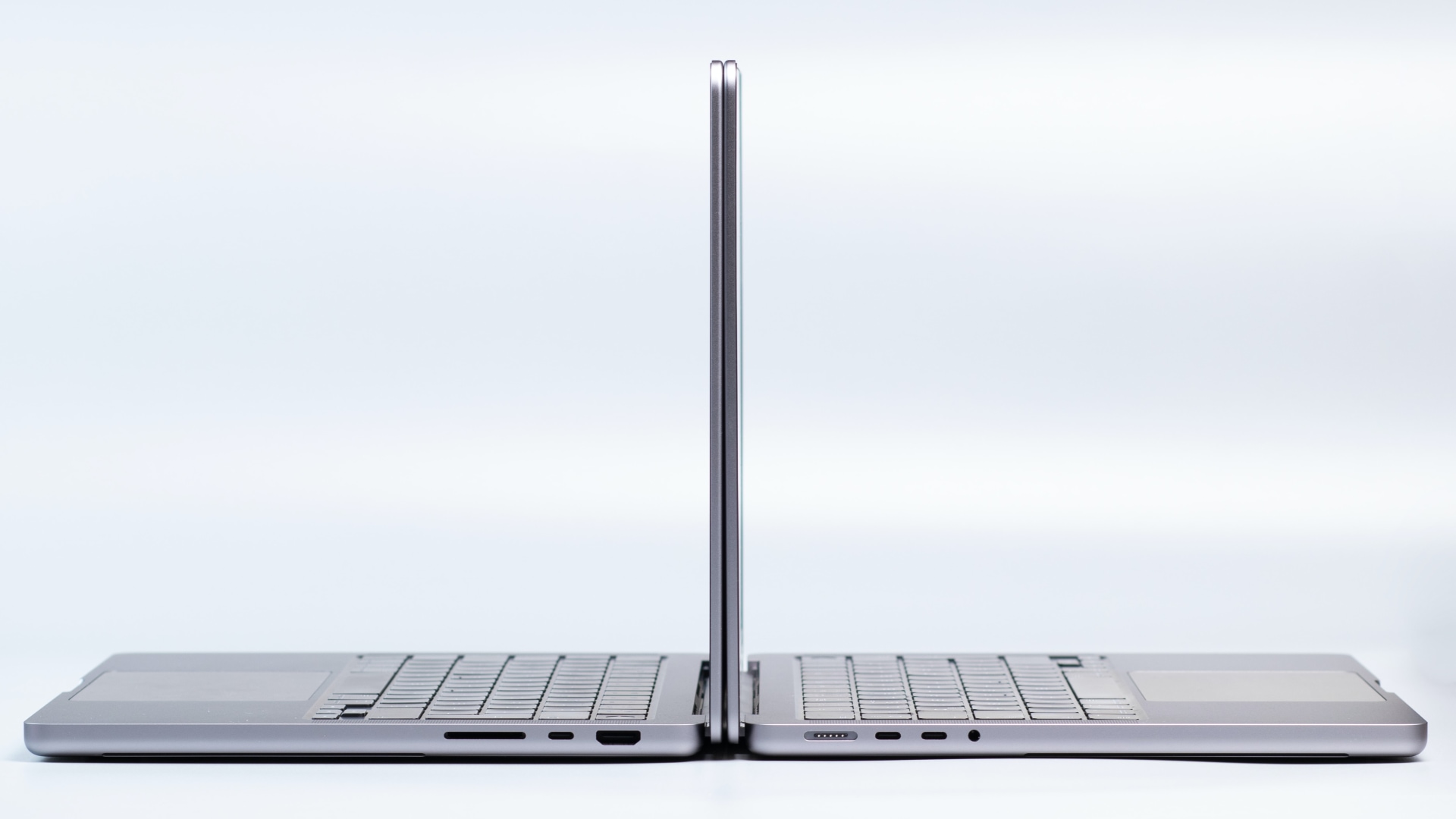 Two MacBook Pro laptops side by side, with their lids open