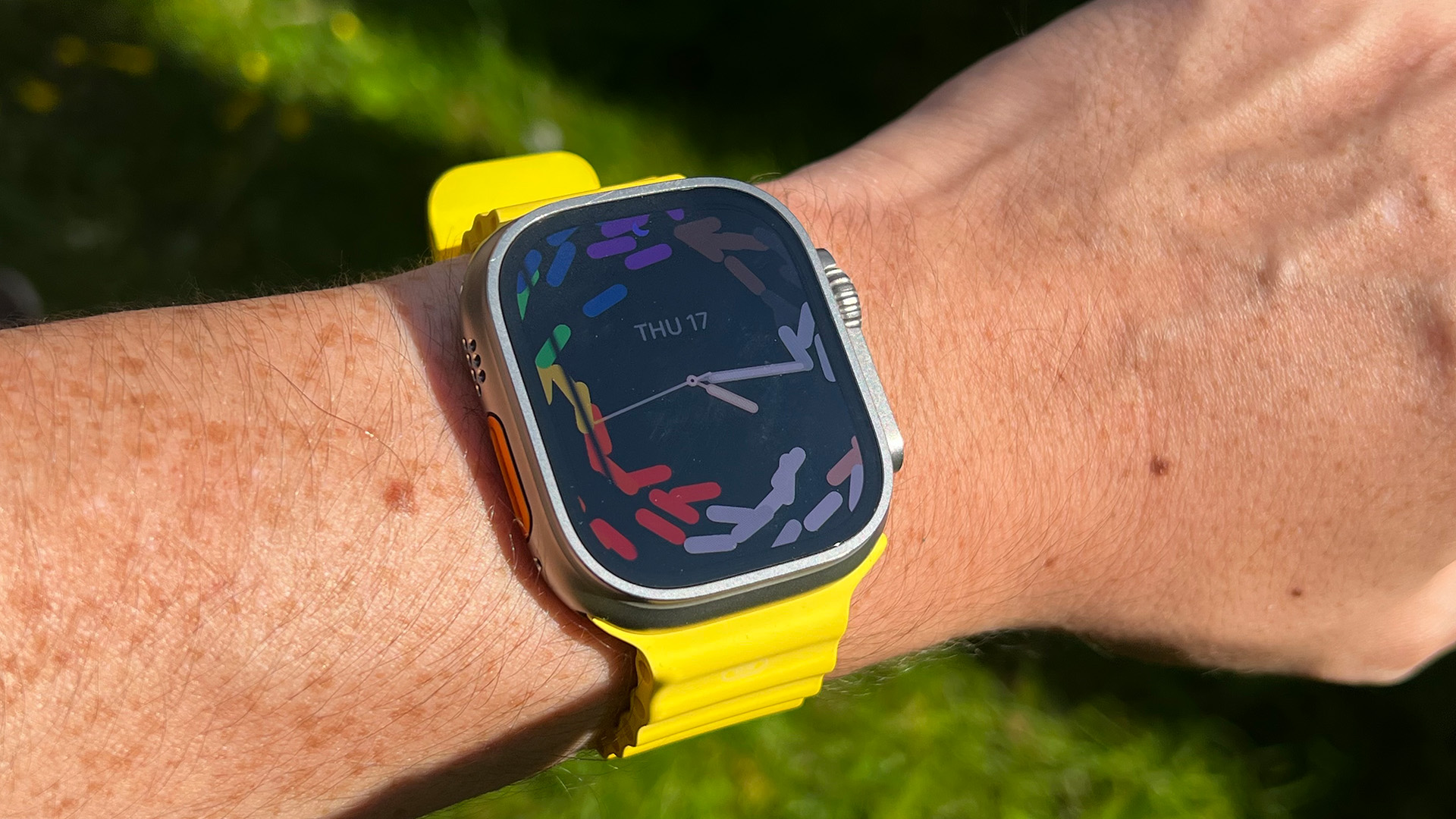 Apple Watch Ultra with yellow band in garden